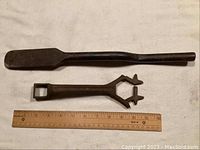 Photo showing both cast iron tools flanked by a ruler for scale, highlighting their size and shape.