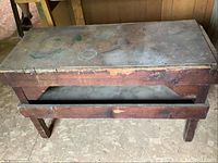 Front angled view showing the wooden butcher table with two layers and visible wear on the surface and edges