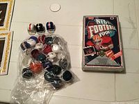 Plastic mini football helmets grouped in clear bag with three outside, plus unopened 1994 NFL football card pack box