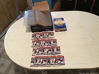 Table with 36 unopened hockey card packs, Ultra Pro card holders box, and plastic holders.