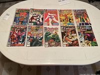 Front covers of 11 Fantastic Four Marvel comics on a white table, each in plastic sleeves, showing colorful vintage artwork with various characters from the series.