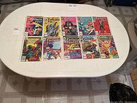 12 Fantastic Four Marvel comics laid on white table, each individually sleeved in protective plastic.