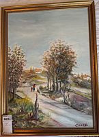 Full view of the framed landscape painting showing the path, trees, figures, and houses.