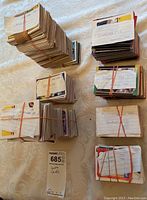 Top view of several bundles of vintage baseball cards tied with rubber bands, some labeled singles and dated 1987 and 1990.