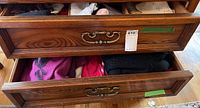Drawer containing pink, red, and black knit sweaters and socks.