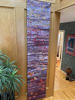 Full view of decorative wall hanging fabric panel hung on wooden door, showing overall length and pattern.