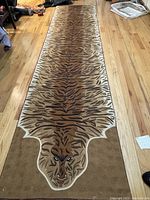 Full view of the embroidered tiger runner carpet laid out on a hardwood floor.
