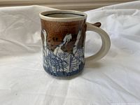Front side view showing the overall shape and bird artwork on the ceramic mug.