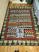 Full view of the Indian embroidered bed cover showing rows of colorful animal motifs including horses, elephants, bulls, with patterned borders.
