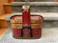 Front view of lacquered Japanese basket on carpeted stairs