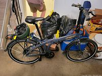 Side view of assembled MEC Origami folding bicycle with helmet on rack and cable lock