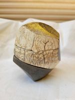 Raku pottery vessel view showing crackled glaze and irregular shape with earthy colors.