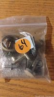 Plastic bag containing assorted metallic tie tacs and cuff links, various styles and sizes.