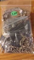 Clear plastic bag containing multiple necklaces with distinct styles visible: one with natural stone beads and one twisted metallic rope chain