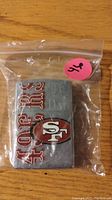 Metal lighter sealed in clear plastic bag, displaying San Francisco 49ers logo and text.