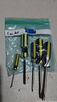 Set of 5 screwdrivers with yellow and black handles inside a clear plastic zip-top bag labeled '5 pc set'.