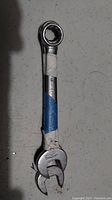 Photo of a single ratcheting wrench with open-ended opposite side and tape around the handle.