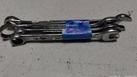 Photo of a set of 5 metal combination wrenches held together with blue tape, showing the open and box ends.