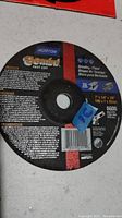 Close-up photo of Norton Gemini Fast Cut grinding wheel showing label with specifications and brand name.