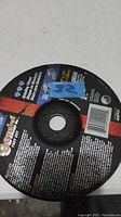 Photo of the Sunbelt abrasive grinding wheel showing the label with specifications and branding.