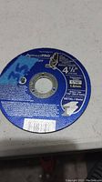 Blue circular metal cut off wheel with detailed label showing size and cutting specifications.