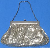 Front view of bright silver mesh handbag with chain handle.
