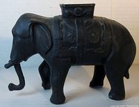 Side profile showing the detailed saddle and locking mechanism with the coin slot on top, trunk extended forward.