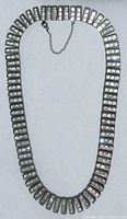 Full view of the 15 inch vintage Art Deco channel set choker necklace laid flat showing the rectangular linked segments with clear rhinestones.