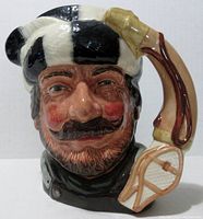 Front view of Royal Doulton trapper mug showing face details, hat colors, and pipe handle.