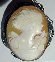 Close-up image of the carved cameo pin showing the lady's profile and silver filigree bezel.