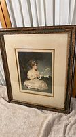Full view of framed print featuring young child, showing frame condition and overall look