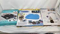 Photo showing boxed itek Smart Body Analysis Scale, Egg Sitter seat cushion, and another support cushion in packaging.