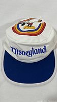 Front view of the vintage white and blue Disneyland hat with Mickey Mouse graphic and 'Disneyland' embroidered text.