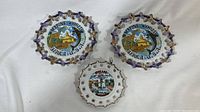 Front view of three hanging collector plates: two Marine World Africa USA plates and one Spokane Washington plate.