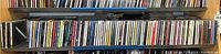 Wide view of two shelves packed with various CDs in jewel cases, showing the collection size and arrangement