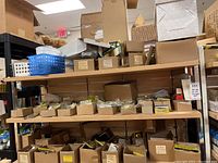 Shelf with boxes and packages of door hardware items including door pulls, door guard, hooks, and locks.