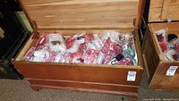 Wooden chest filled with various wrapped gift bags of different colors and patterns