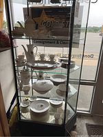Shelf with Fitz and Floyd Palais teapot, Classique Dor cups and saucers, and Rosenthal Aida plates and bowls with gold trim and wheat design