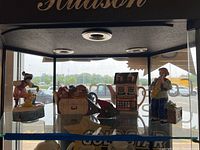 Display case photo showing all five items from the lot with natural outdoor light reflecting through the glass.