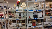 Two beige plastic shelving units shown with various household items on them. Shelves appear sturdy with vented slats.