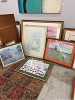 Four framed wall art prints grouped on floor, showing varying frame styles and sizes.