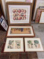 Four framed fruit and vegetable wall art prints arranged on a floor, showing size and frame detail.