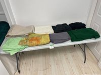 Overview of all fabric backdrops on a table, showing variety in color and partial folding of materials, used for size and color reference.