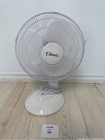 Front view of the white Classic branded tabletop fan showing the grill and base.