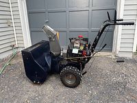Side view of Murray Select snowblower showing wheels, motor, and snow intake housing with some surface rust.