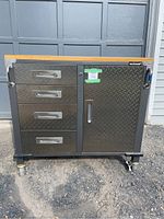 Front view showing four diamond plate drawers and single door with butcher block top