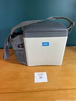 Closed mini travel cooler and warmer with shoulder strap visible
