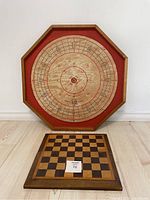 Crokinole board showing octagonal wooden surface with scoring circles and chess/checker folding board below