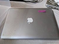 Closed top view of silver MacBook Pro showing Apple logo and surface scratches