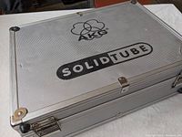 Closed silver metal hard case with black AKG logo and Solid Tube branding on the lid.